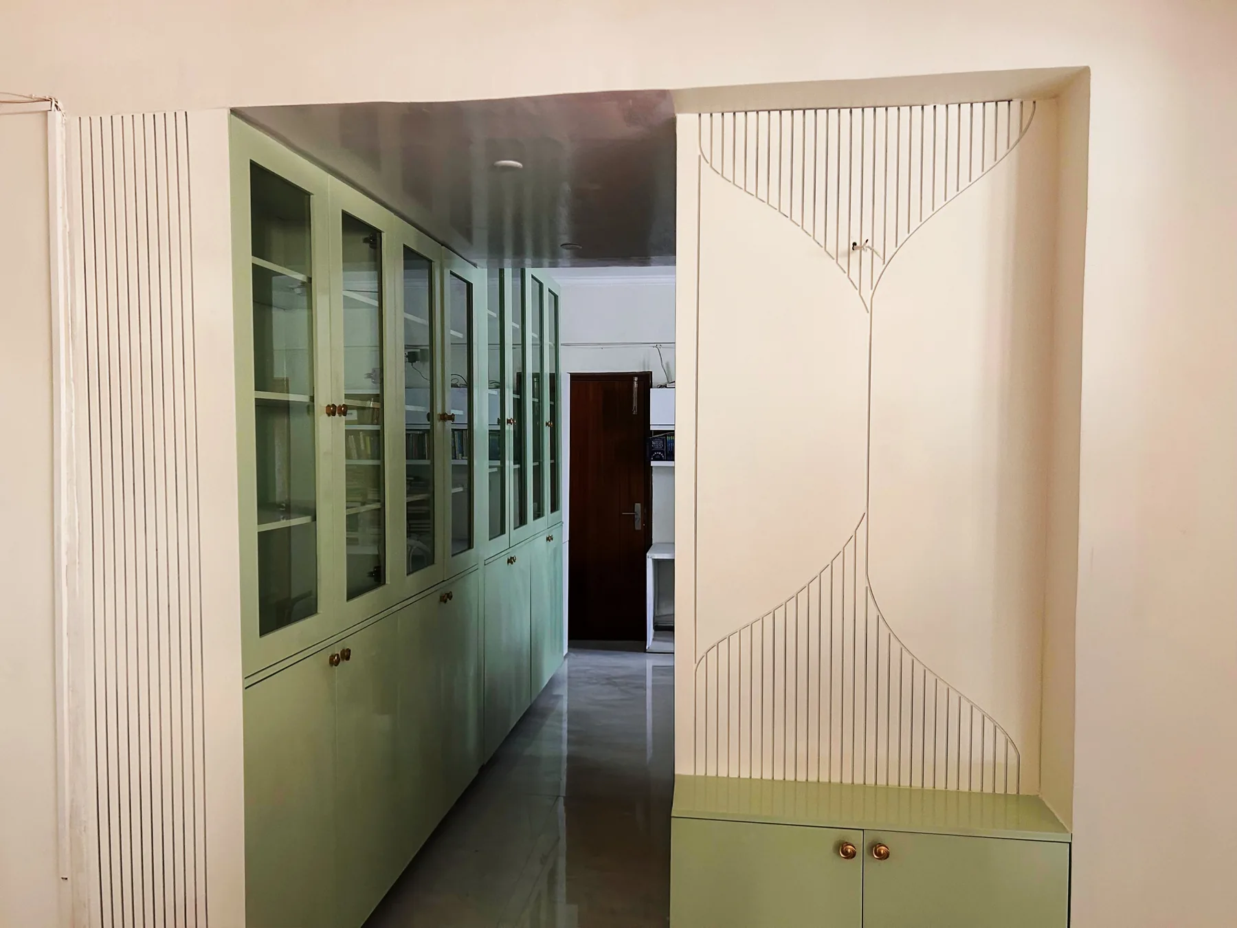 Integrated white and green cabinetry at the AWHO Greater Noida residence